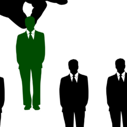 A hand picking a man out of a crowd